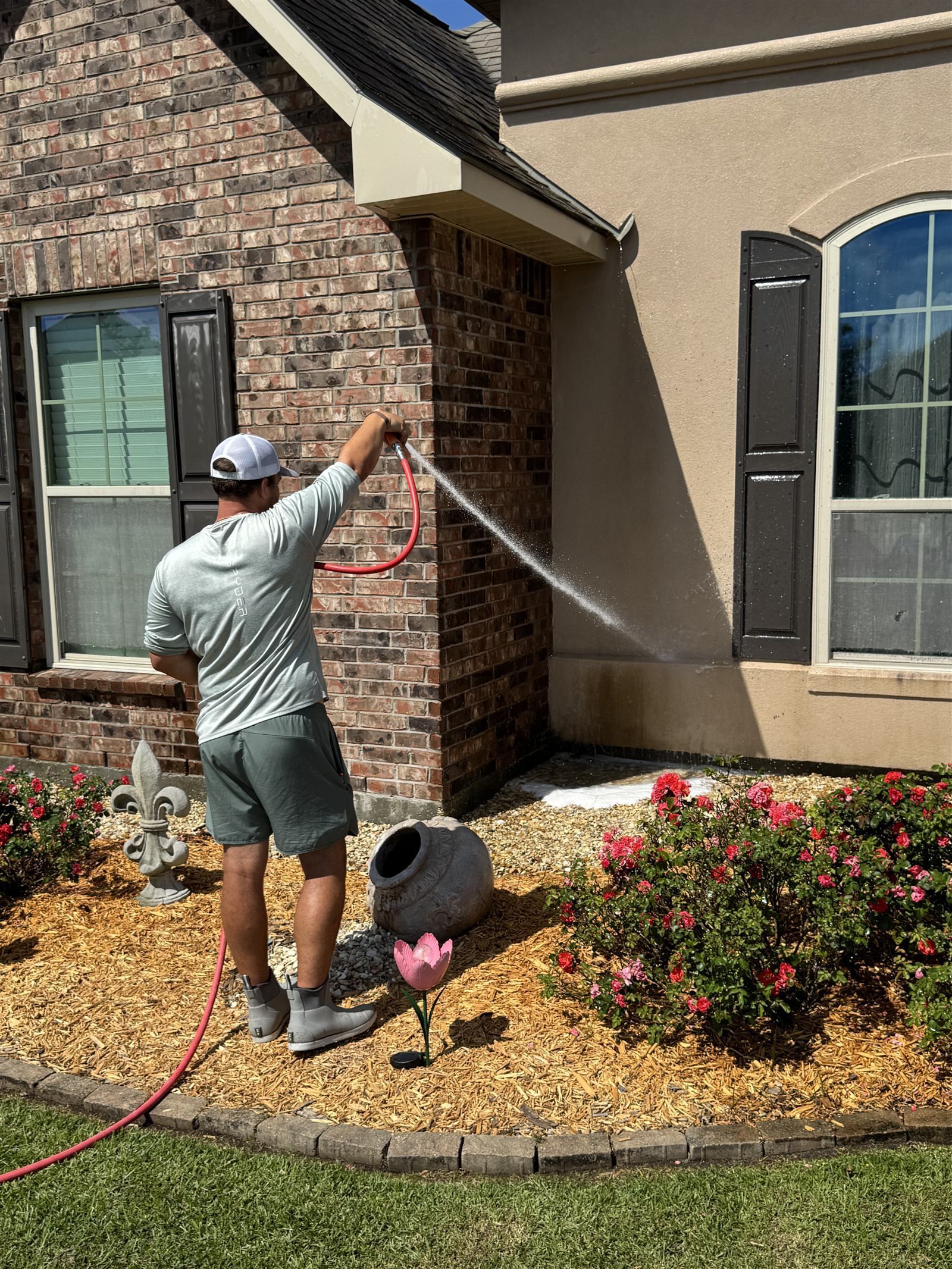 Soft washing stucco exterior — Dixon applying treatment to front of home
